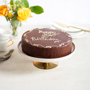 Celebration Cake on a table with flowers, cups and plates